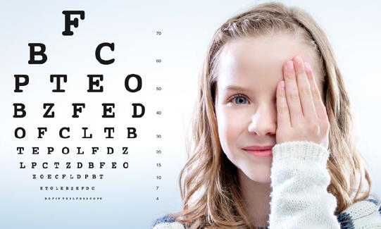 Ein Mädchen, welches sich ihr linkes Auge zuhält und einen Sehtest mit verschiedenen Buchstaben in unterschiedlichen Größen neben sich hat.