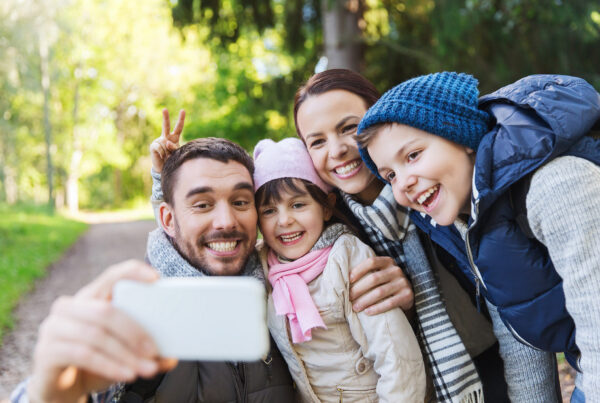 Familie mit Mann, Tochter, Frau und Sohn macht ein Selfie während dem Spaziergang im Wald